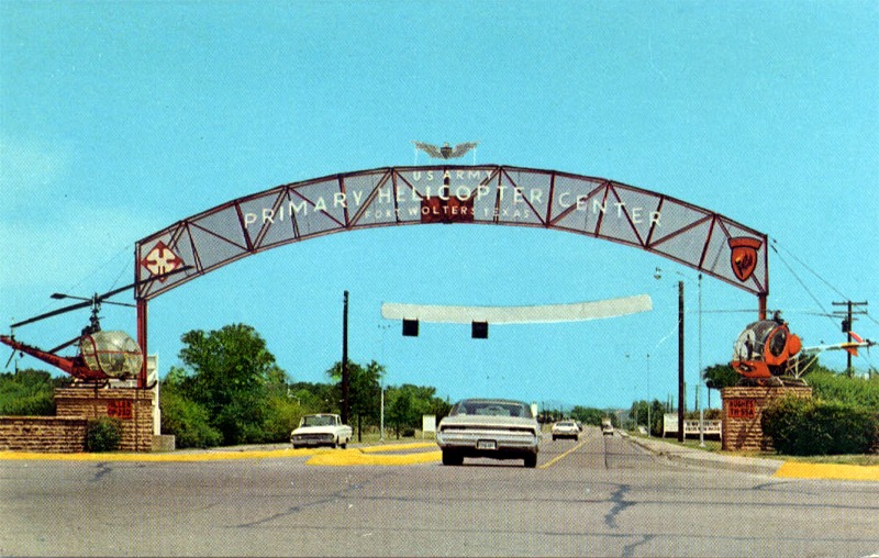 A car driving under an arch on the road.